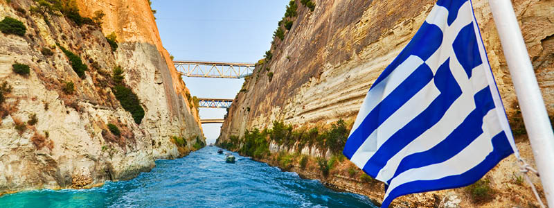 Korinthkanalen med Greklands flagga och turkost vatten, Grekland.